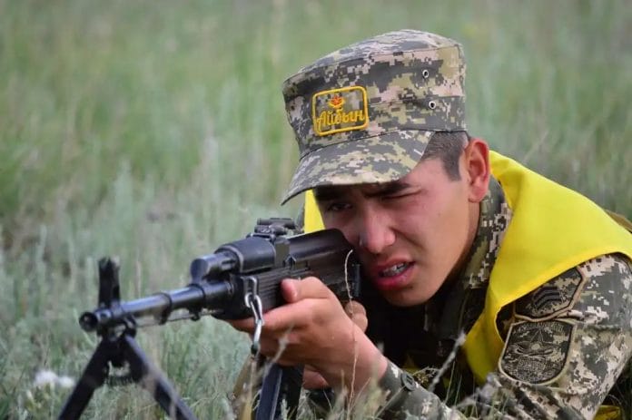 Военный лежит с автоматом